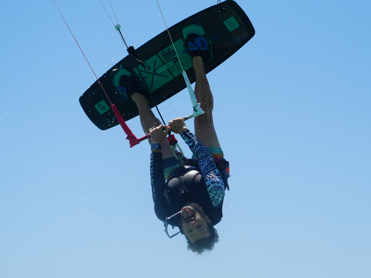 girl doing basic jump with kite using an eleveight kiteboard and wearing a kite tribe lycra